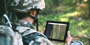 Soldier viewing coastal terrain on a tablet