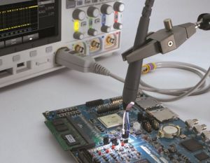 An oscilloscope probe connected to a device under test.